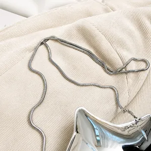 Primer plano detallado de una correa de cadena de serpiente plateada en un bolso de acrílico