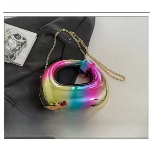 Close-up of holographic rainbow metallic handbag with gold chain strap detail