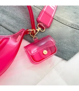 Detail view of pink jelly PVC bag showing sturdy gold hooks and mini charm accessory