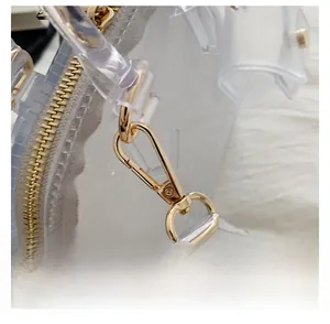 Detail shot of golden metal zipper and detachable hook on a transparent PVC jelly bag