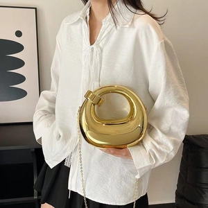 Elegant gold acrylic evening handbag with a unique bean shape and metallic chain strap