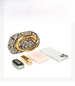Snake skin pattern bucket bag with round gold handle showing interior capacity with essentials