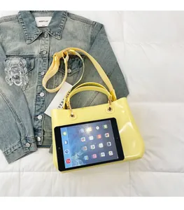 Spacious yellow patent jelly bag showing capacity for a tablet with top handles