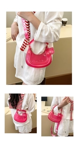 Detail of rose pink transparent jelly dumpling bag with embossed logo and wide strap