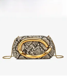 Close-up of the snakeskin textured leather with a large sculptural gold metal ring detail
