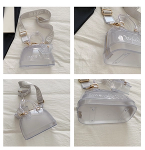 Detail view of transparent grey PVC jelly bag with wide strap and gold hardware accents