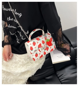 Détail du sac matelassé blanc avec imprimé fraise et bandoulière en chaîne argent