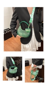 Detail of green transparent jelly moon bag with embossed logo and printed strap