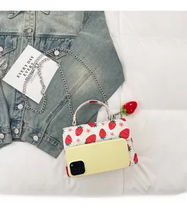 Vue de la capacité du sac bandoulière matelassé blanc avec imprimé fraise et chaîne