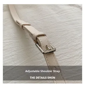 Close-up of adjustable shoulder strap on cream Saffiano leather handbag with silver buckle