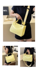 Detail of yellow jelly tote bag showing PVC material with wide letter-print strap