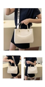 Detail of cream patent leather tote with gold hardware and logo webbing strap