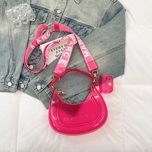 Fuchsia pink transparent jelly bag with canvas strap and mini pouch on denim background