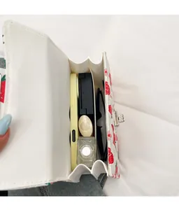 Vue de dessus montrant la grande capacité du sac à main blanc avec motif de fraises