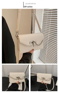 Detail view of cream white Kelly bag showing fine toothpick texture and metal clasp lock