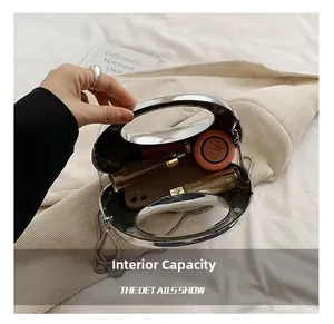 Detailed interior capacity of transparent mini bag showing makeup items and silver handle
