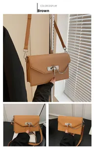 Detail view of brown Saffiano leather texture with silver twist lock and metal chain
