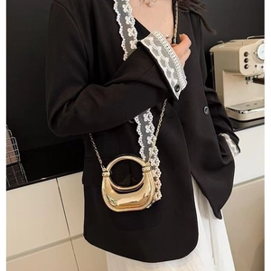 Chic gold metallic half-moon bag with circular handle and chain strap for women