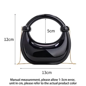 Glossy black crescent handbag with metallic chain and spherical handle details
