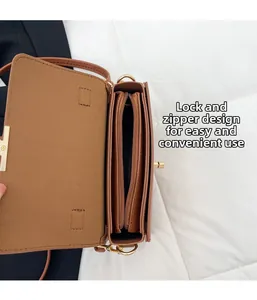 Détail des compartiments intérieurs avec boucle et fermeture éclair sur un sac marron