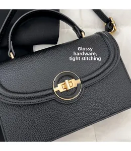 Détail d'un sac à main en cuir noir avec ferrures dorées et coutures de précision