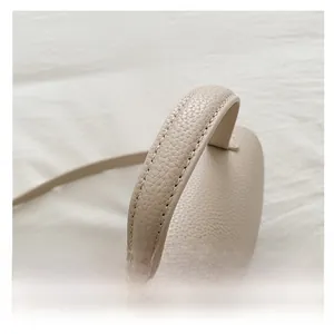 Detail of comfortable beige handbag handle and luxury lychee pattern leather texture