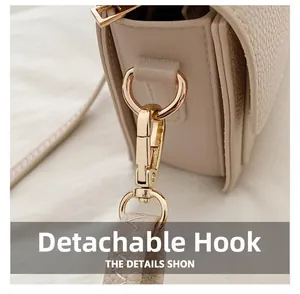 Detailed macro view of the detachable golden metal hook and litchi grain leather texture