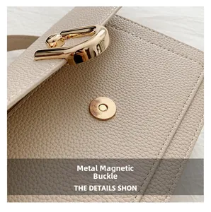 Detailed macro view of the cream lychee grain leather bag with a golden magnetic snap buckle