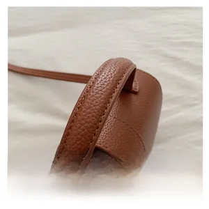 Detailed macro of brown lychee grain leather handbag with neat stitching and comfortable handle