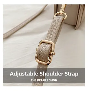 Detail view of the adjustable beige leather strap with gold buckle and lychee texture
