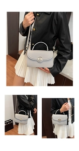 Detail of light grey lychee pattern leather handbag with gold twist lock and strap