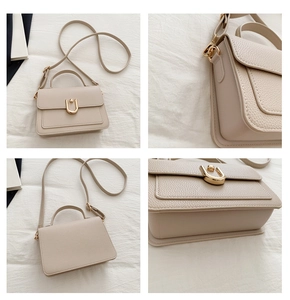 Detail view of beige lychee texture leather bag with gold U-shaped buckle and strap