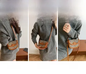 Λεπτομέρεια vintage τσάντας σέλας με καφέ δερμάτινο φινίρισμα και χρυσό κούμπωμα