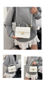 Close-up of white lychee pattern leather square bag with gold metal round swivel lock