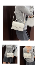 Detail of white lychee pattern leather crossbody bag with elegant gold metal buckle