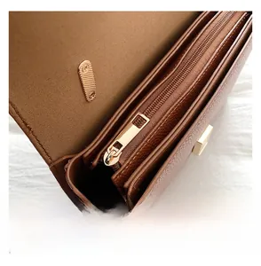 Détails de l'intérieur du sac en cuir marron avec fermetures dorées et bouton aimanté