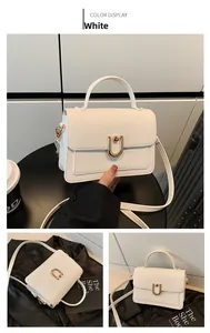Detail of white lychee pattern leather handbag with gold U-shaped buckle and straps