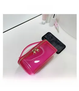 Pink translucent TPU makeup bag with dual gold zippers showing large storage capacity