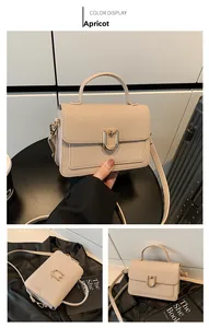 Detail of apricot pebbled leather handbag with U-shaped gold metal buckle and strap