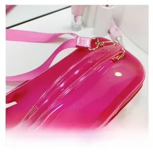 Detailed top view of rose pink PVC jelly bag with transparent handle and metallic zipper