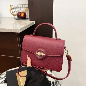 Chic burgundy lychee leather handbag with golden metal lock and top handle for women