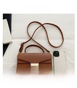 Sac en cuir marron avec boucle dorée comparé à un smartphone pour la taille réelle