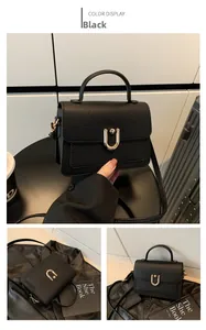 Close-up of black litchi grain leather bag featuring a golden U-shaped metal lock