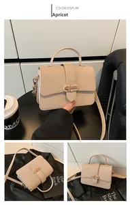 Detail view of apricot textured leather handbag with elegant gold metal lock and shoulder strap