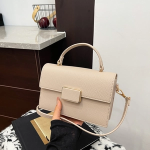 Elegant beige leather crossbody bag with top handle and gold clasp for women