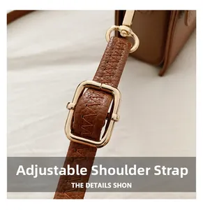 Detail of adjustable caramel lychee grain leather strap with gold buckle and swivel hook