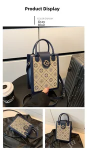 Detailed view of grey-blue leather handbag with floral pattern and clover metal buckle