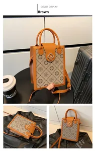 Detail of brown canvas tote with gold clover lock, leather handle and detachable strap