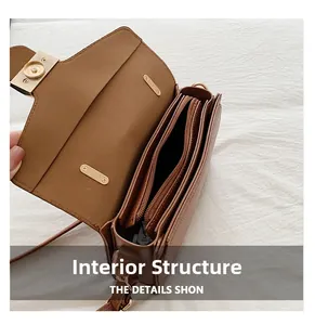 Detail view of brown pebbled leather bag with triple accordion compartments and gold clasp