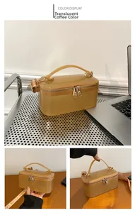 Detail view of coffee-colored transparent PVC handbag with metallic zip and wide fabric strap